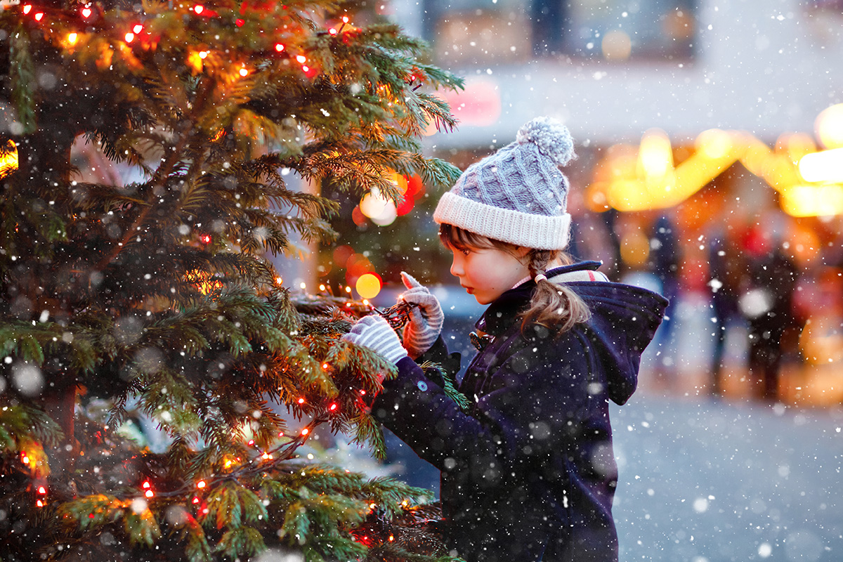 Young girl looking at Christmas tree at Christmas Market