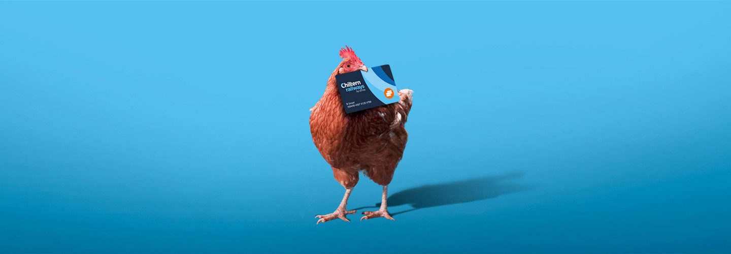 Chiltern Chicken folding a Smartcard in it's beak with a Blue gradient background